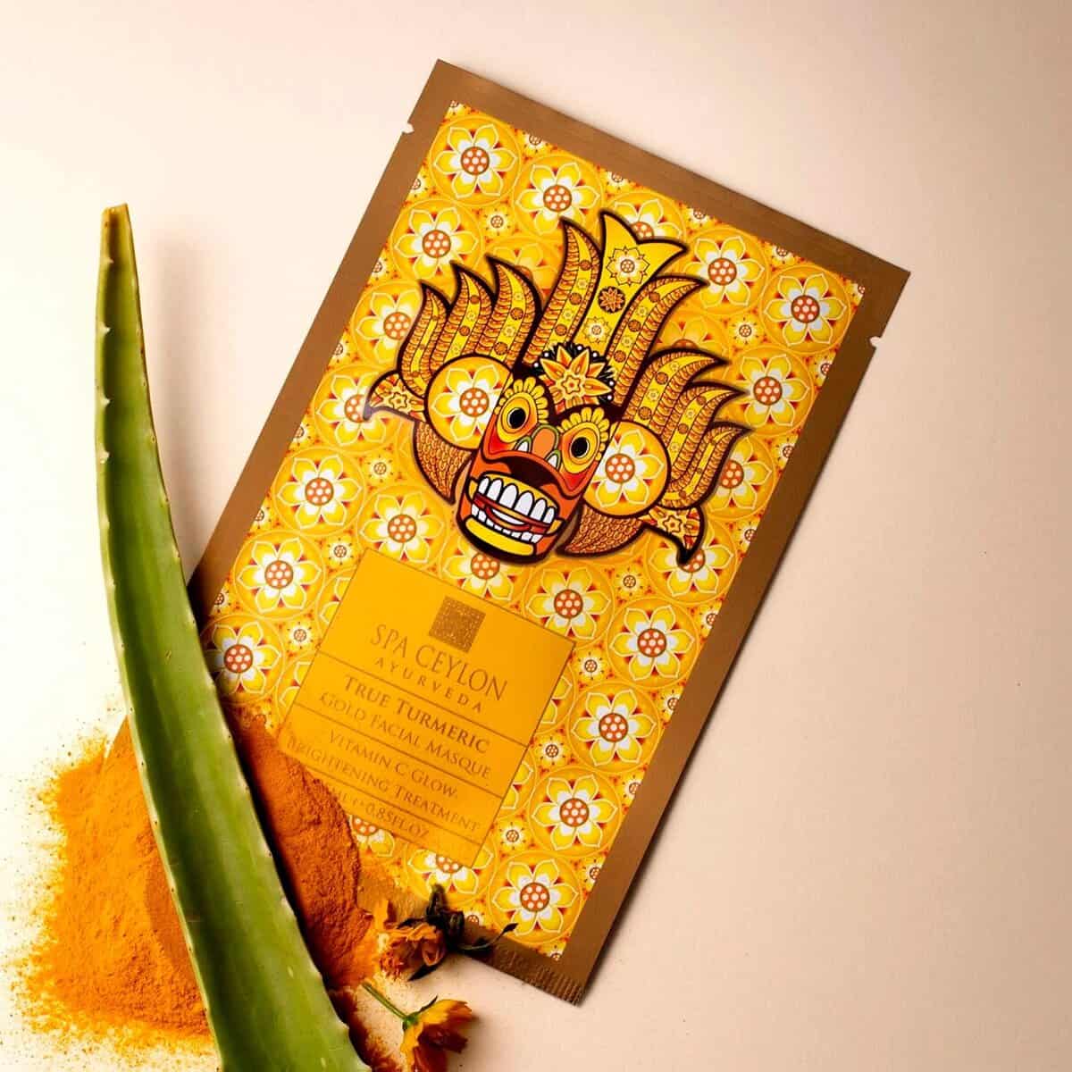 Golden yellow traditional Sri Lankan mask with intricate patterns, promoting Spa Ceylon Ayurveda products.