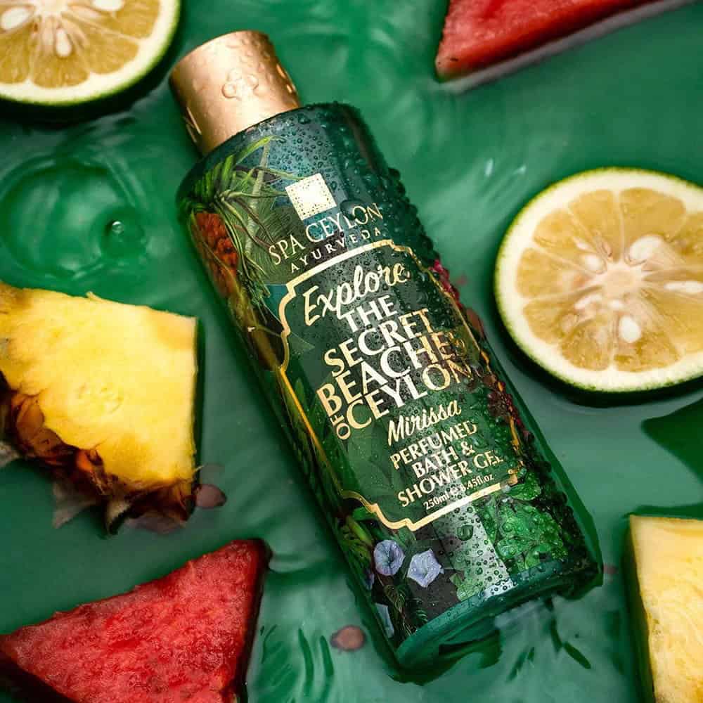 Pineapple and lemon slices with Spa Ceylon Ayurveda shower gel bottle, tropical spa product, exotic fruit ingredients for skin care.