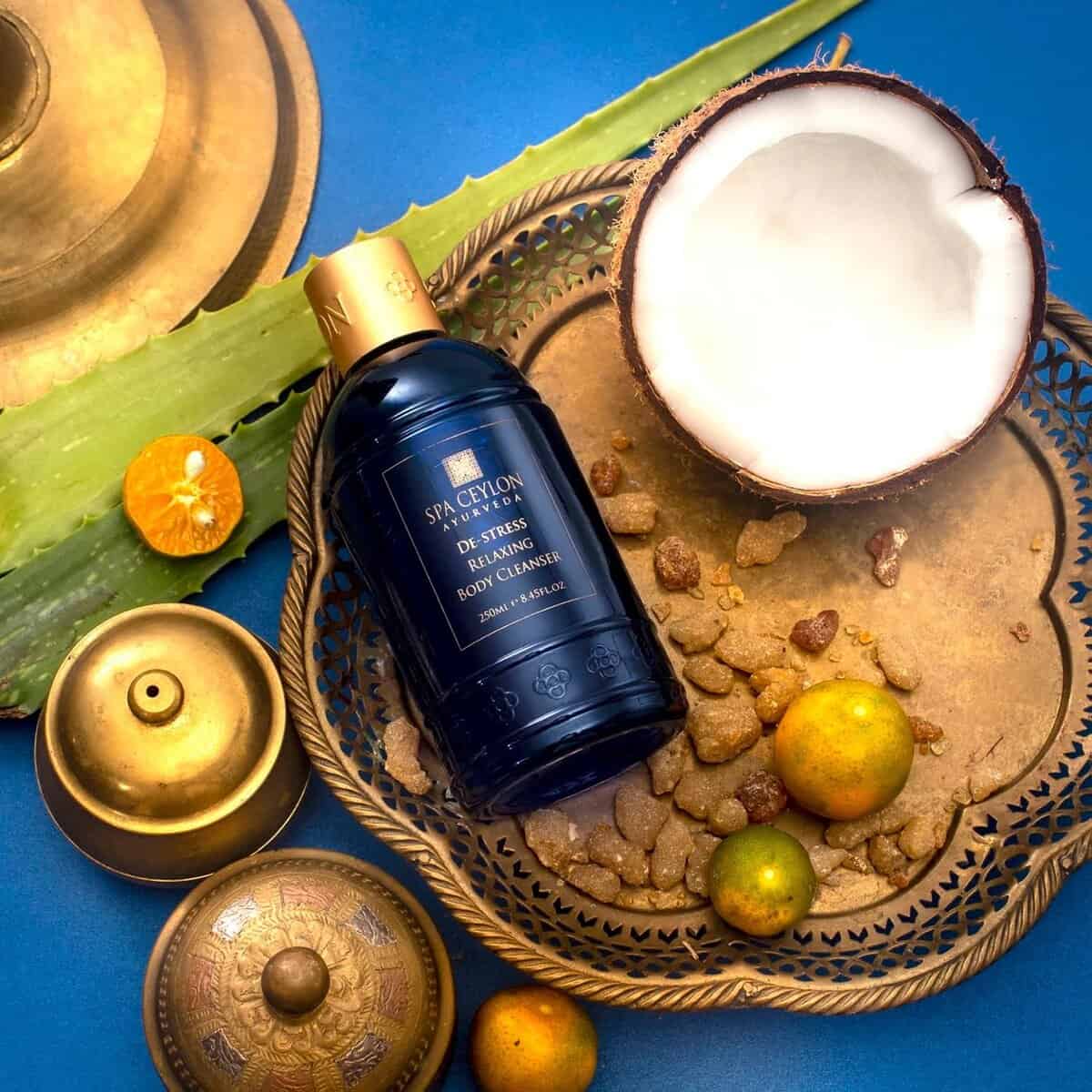 Luxury spa body cleanser with coconut and citrus, traditional brass candles and elegant decor.